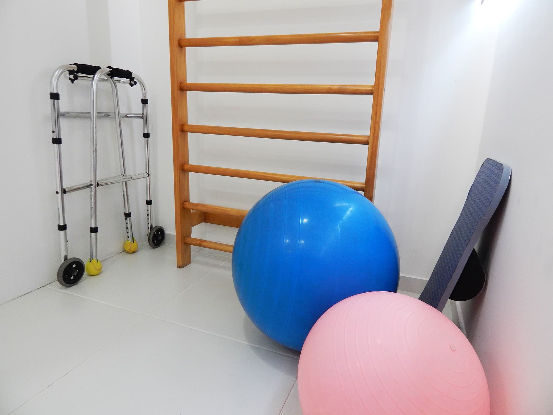 Photo de matériel de rééducation dans le coin d'une salle : ballons grands formats et cadre de marche